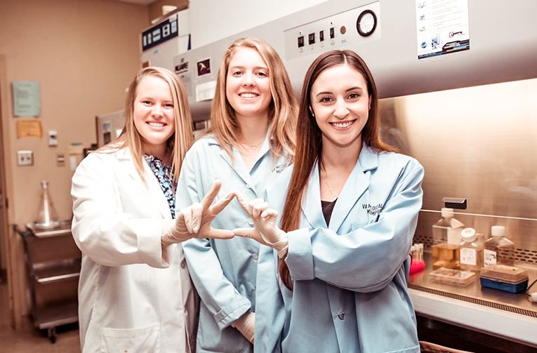 Three collegiate research interns in the lab